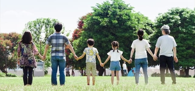 写真：人が手をつないでいる後ろ姿